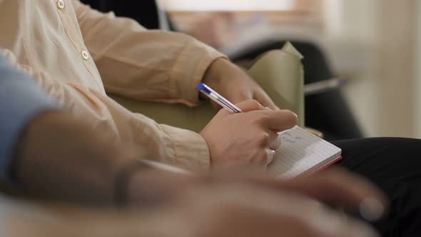 Closeup Hands of Adult Woman Noting at Seminar