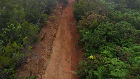 Aerial View of Mountain Slopes Covered with Red Clay Soil and Green Vegetation