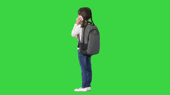 Smiling Girl with Backpack Talking on the Phone About Her Day at School on a Green Screen Chroma Key