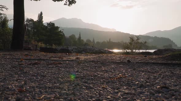 Trekking lakeside, morning mountain panorama, sunrise, shiny water of Lake Garda