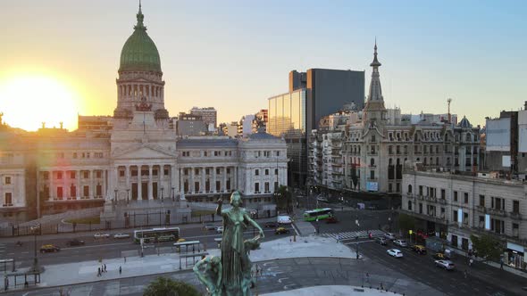 Aerial rising over Monument of Two Congresses with Argentine Congress Palace in background at golden