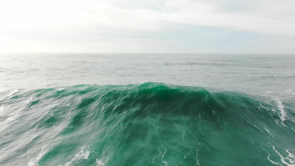 Azure Wave with Foam Rolls on Ocean Surface on Calm Day