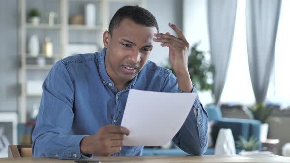 Young African Man Upset After Reading Documents Feeling Sad
