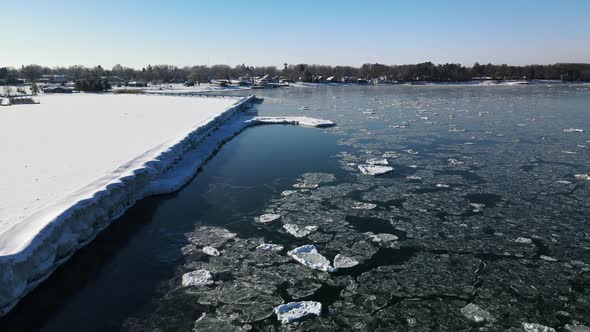 Drone footage along ice-covered pier on Lake Huron in Michigan