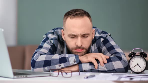 Overworked Male Feeling Tiredness at Workplace Lying on Table