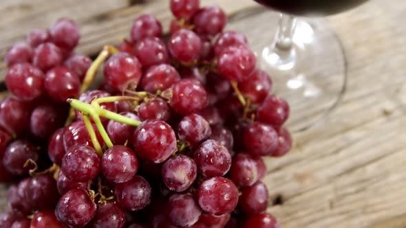 Grapes and red wine on wooden plank