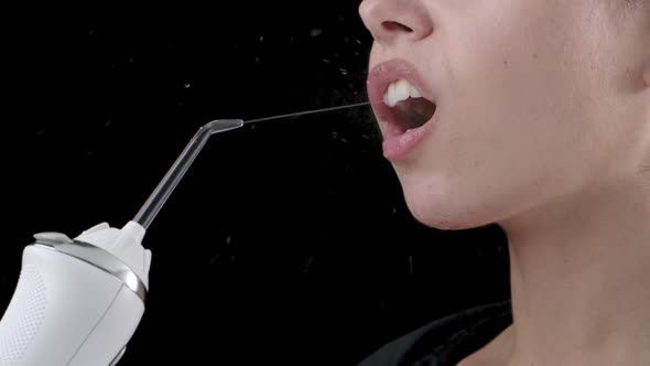 Water Flosser Stream Cleaning Young Woman's Teeth