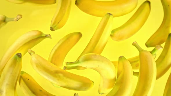 Super Slow Motion Shot of Fresh Bananas on Yellow Background Flying Towards Camera at 1000Fps