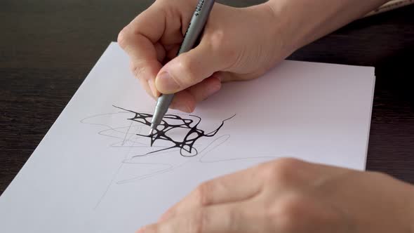 Designer Work on Paper Using a Black Marker