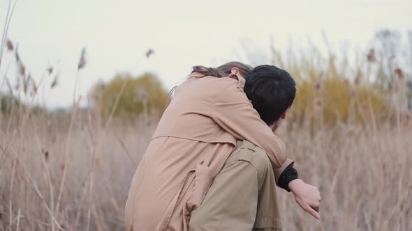 Woman and Man in Beige Coats Having Date in Reeds