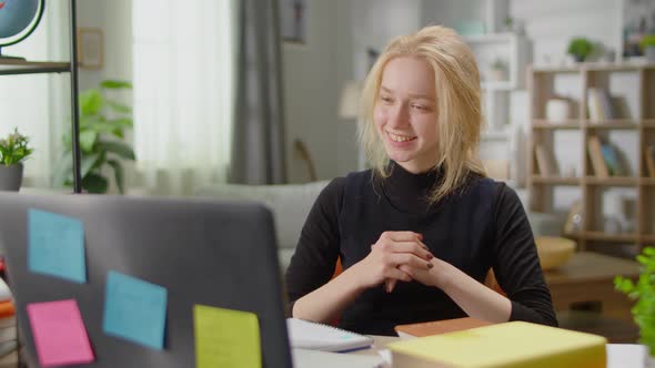 Young Woman Communicating By Video Call at Home in the Living Room at the Desk