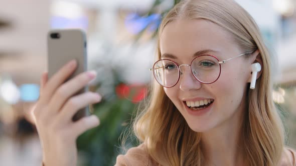 Closeup Caucasian Girl Talking Video Call Young Millennial Woman Using Phone and Wireless Headphones