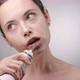 Young Woman with Pulled Hair Cleaning Teeth with Water Flosser and Smiling - VideoHive Item for Sale
