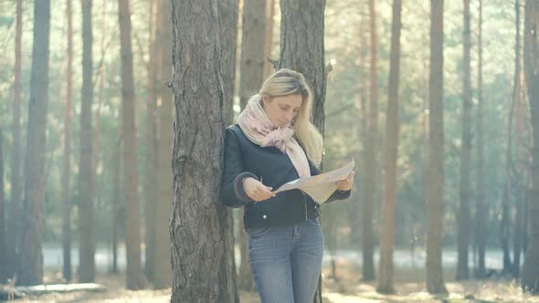 Woman Tourist Paper Map.Tourist Lookin On Map.Traveler Explore Forest With Map.Autumn Forest