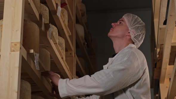 Young Attractive Cheesemaker Holding Tasty Fresh Organic Milky Cheese Checking