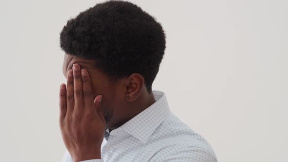 Serious African man thinking about something and kneading temples