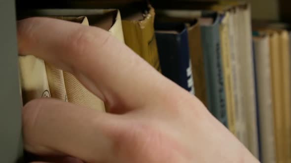 Man Taking A Books From The Shelf