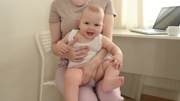 Young Single Mother Work From Home Office with Laptop Computer During Quarantine Playing with Little Baby