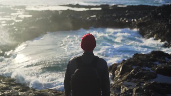 Man Watching Sea Flow Into Rock Pools