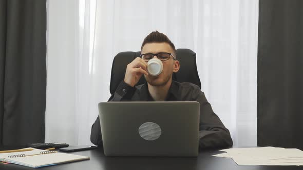 Successful businessman drinking coffee in his modern office. Business concept