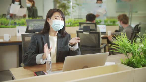 A Young Businesswoman is Disinfecting Her Hands