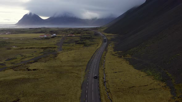 Aerial of Car Driving Along an Empty Coastal Road In Iceland Stunning Landscape