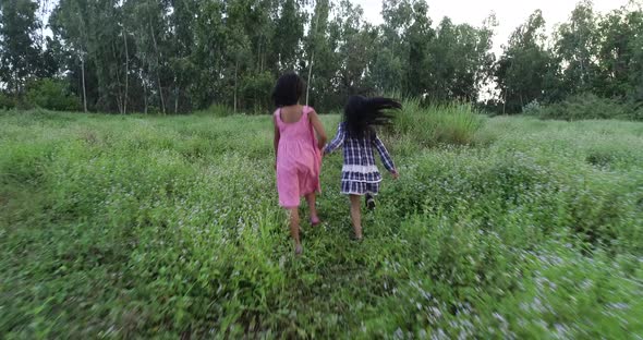 4K Two little girls running around the park