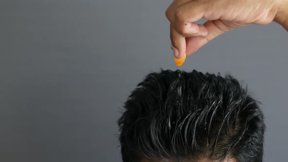 Men Applying Capsule Oil on Hair