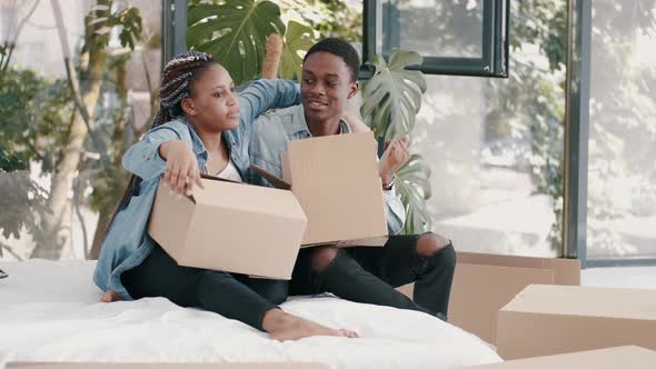A Young African-American Couple Are Packing Boxes with Stuff