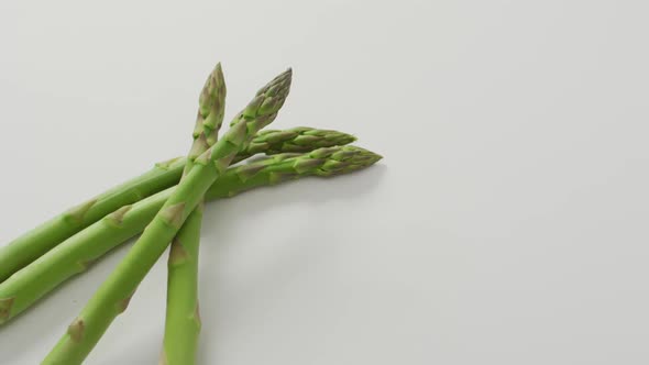 Video of close up of fresh asparagus with copy space over white background