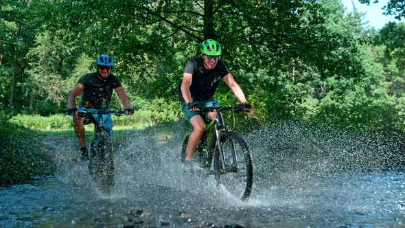 Super Slow Motion Shot of Two Men on Mountain Bike Crossing The River at 1000 Fps