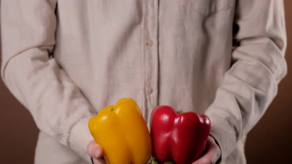 Hand Holding Red Sweet Pepper or Red Bell Pepper with Fresh Sweet Pepper in Super Market