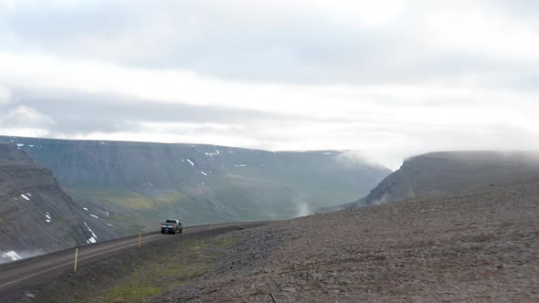 Pickup Truck Driving On Dirt Road With Scenic Mountain Views At  Westfjords Region In Iceland. - aer