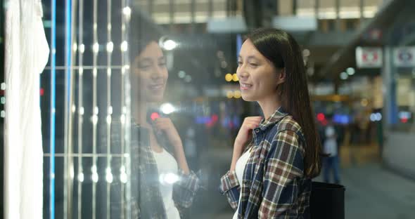 Woman go window shopping at night