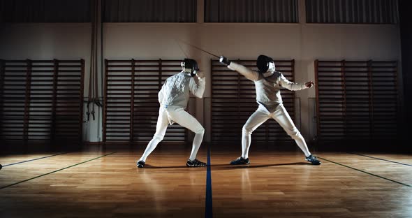 Two Men in Fencing Gear Duelling with Foils