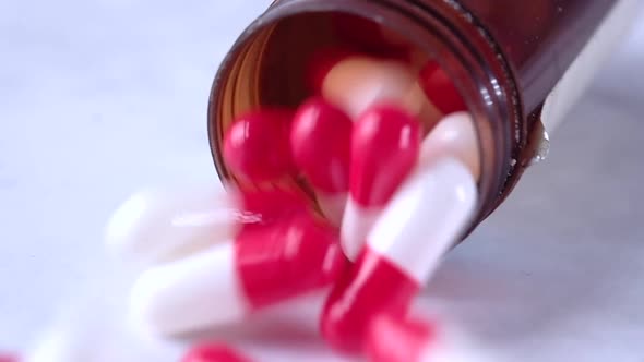 Slow Motion of Capsules Dropping on White Background 