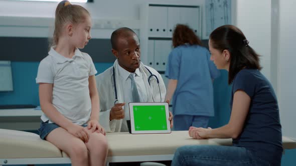 Male Doctor Pointing at Tablet with Horizontal Green Screen