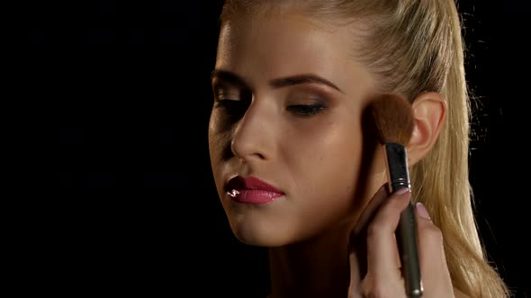 Makeup Artist Putting Blush on Her Face with Brush, Black, Closeup