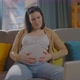 Pregnant Woman Sitting on the Couch is Experiencing Discomfort and Inconvenience - VideoHive Item for Sale