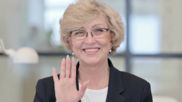 Portrait of Old Businesswoman Waving at the Camera