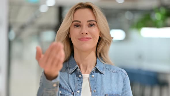 Cheerful Young Casual Woman Pointing and Inviting 