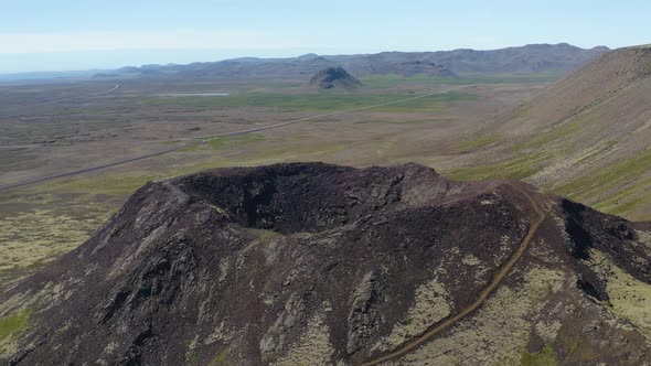 Aerial flyover volcano crater and scenic landscape of Iceland Island during bright sunlight and blue