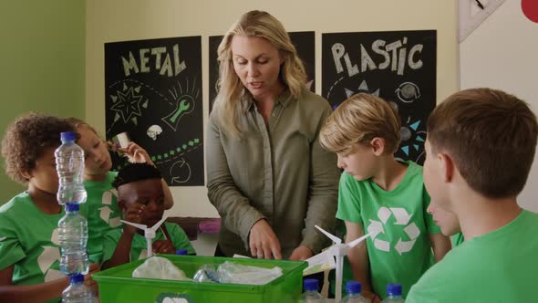 Female teacher teaching about recyclable materials in the class