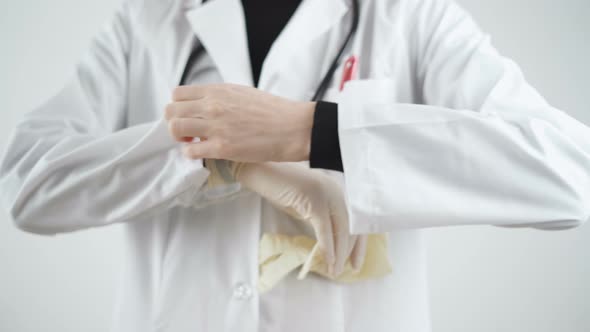 Doctor Putting Sterile White Gloves Over White Coat Sleeve