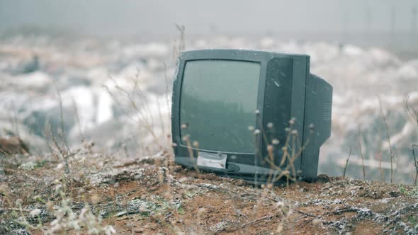 Snowing Landfill Site with a Thrown-out TV