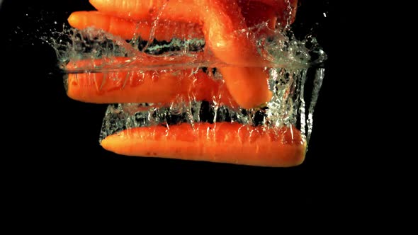 Super Slow Motion Ripe Carrot Falls Under Water with Air Bubbles