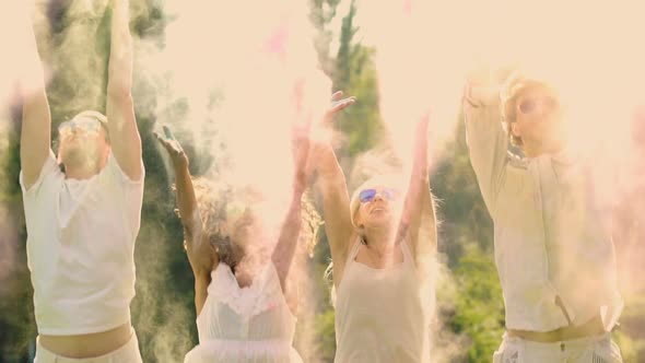 Attractive Best Friends Celebrating Life Outdoors, Spraying Colored Powder Paint