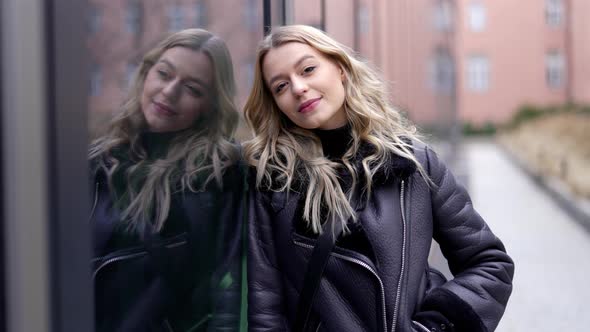 Happy Woman Leaning on Glass Wall