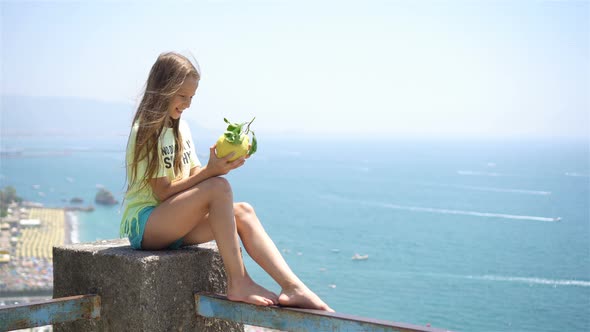 Big Yellow Lemon in Hand in Background of Mediterranean Sea and Sky.