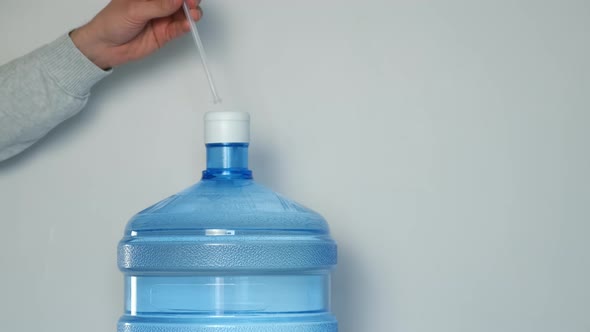 Man's Hands Pour Water Into Glass From an Automatic Water Cooler Closeup View